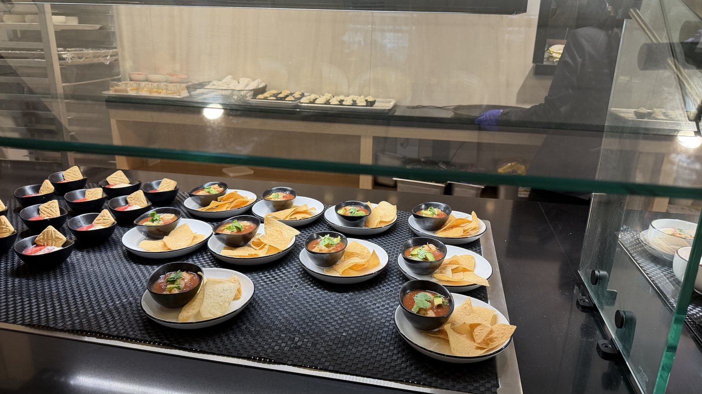 A lounge buffet counter under glass, set with rows of small plated dishes and bowls