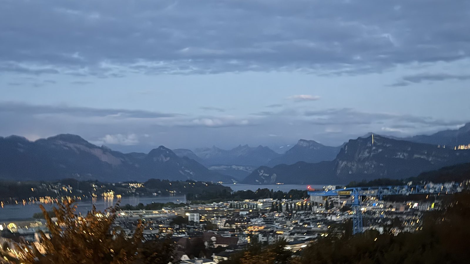 Lucerne at night from the Château Gütsch terrace, the town lit below and the last light over the mountains