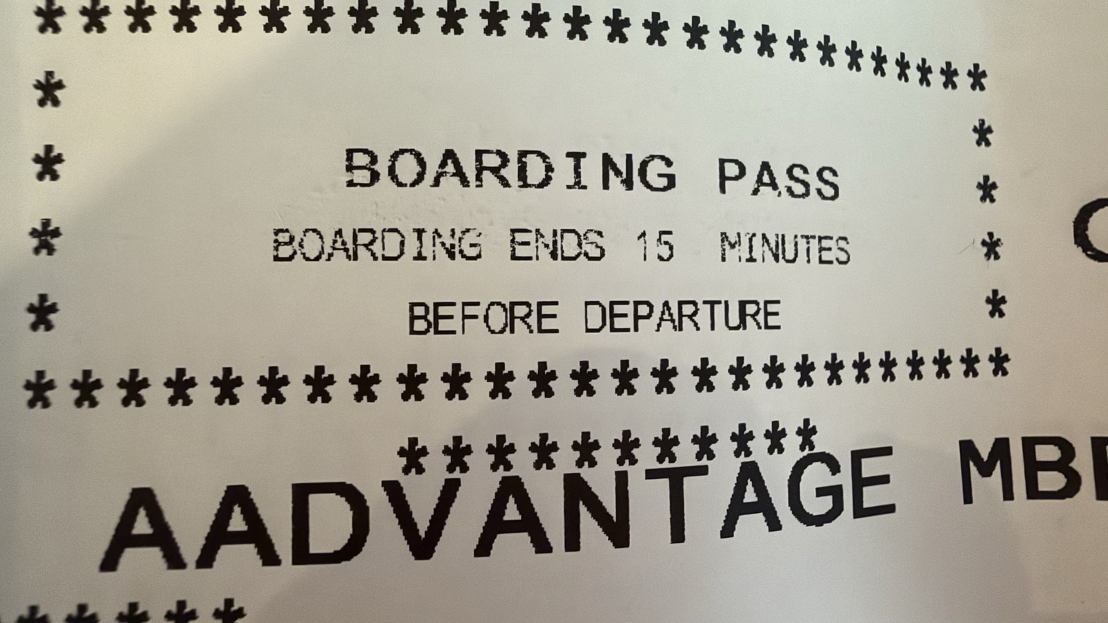 A printed American Airlines boarding pass showing the AAdvantage membership line above the boarding instructions